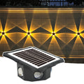 Buitenstee Terra — solar wandlamp met bewegingssensor, geïnstalleerd op een buitenmuur met sterpatroon lichteffect (tijdelijke leveranciersfoto, ter preview)